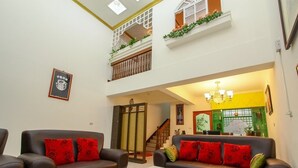 A spacious living area with two sofas, a staircase, and a balcony with plants. - Meiden (Wujie)