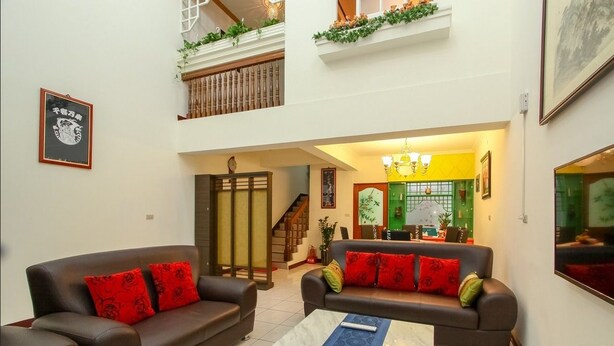 A spacious living room with two sofas, a coffee table, and a staircase leading to an upper floor. - Meiden (Wujie)