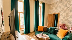 A living room with a green sofa, wooden coffee table, and a television. - Sahil Inn Hotel (Baku)