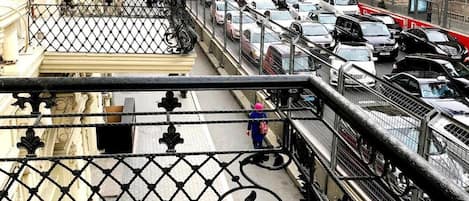A busy urban street with a pedestrian bridge and a view of buildings.