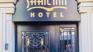 A hotel entrance with a black door featuring ornate metalwork and a sign above that reads "Sahilinn Hotel". - Sahil Inn Hotel (Baku)