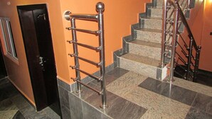 Una escalera con barandillas de metal y una puerta a la izquierda.