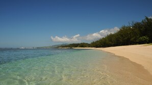 A beach with clear shallow waters, a sandy shore, and a line of trees in the background. - Chalet Oase de Riambel (Riambel)