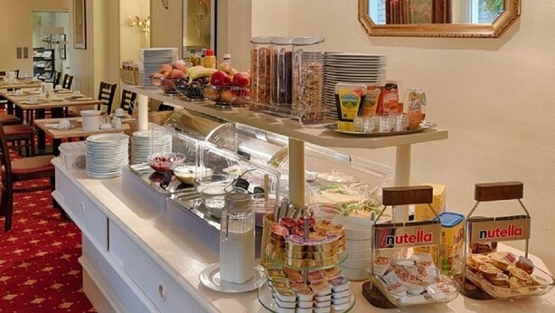 A buffet area with various food items and condiments, including jars labeled 'Nutella'. - Hotel Kronprinz (Minden)