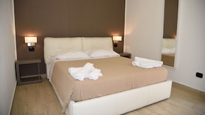 Una cama bien hecha con sábanas blancas y una colcha color beige en una habitación de hotel.