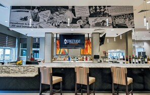 A bar area with a counter, bar stools, and a television screen displaying 'STREETLIGHT KITCHEN & BAR'. - Holiday Inn & Suites Philadelphia W - Drexel Hill by IHG (Drexel Hill)
