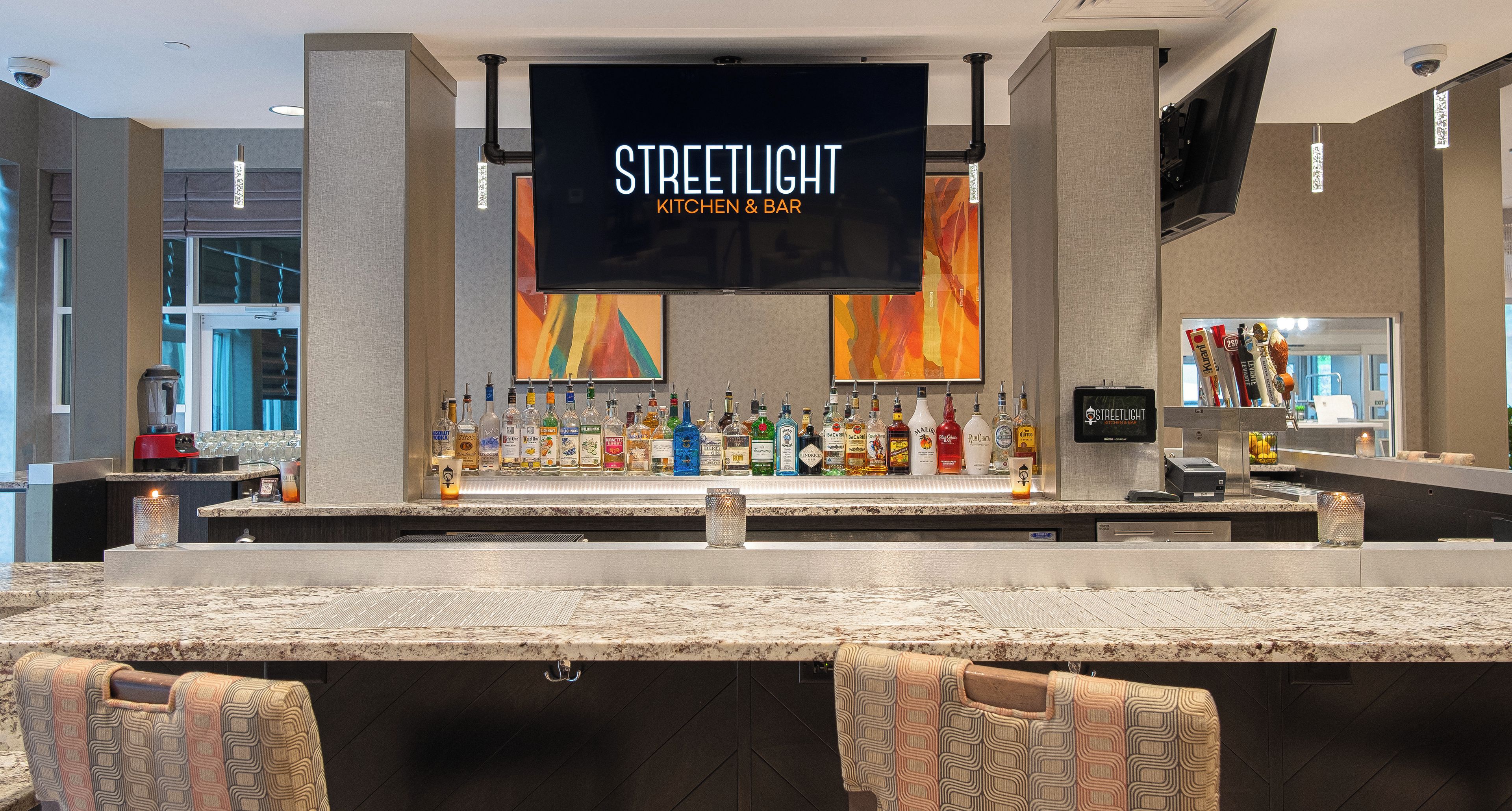 Zona de bar con un letrero que dice 'STREETLIGHT KITCHEN & BAR' y una variedad de botellas de licor.