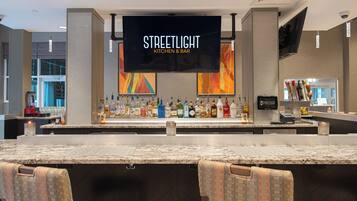 Zona de bar con un letrero que dice 'STREETLIGHT KITCHEN & BAR' y una variedad de botellas de licor.