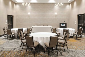 A conference room with round tables and chairs, a podium, and a carpeted floor. - Holiday Inn & Suites Philadelphia W - Drexel Hill by IHG (Drexel Hill)
