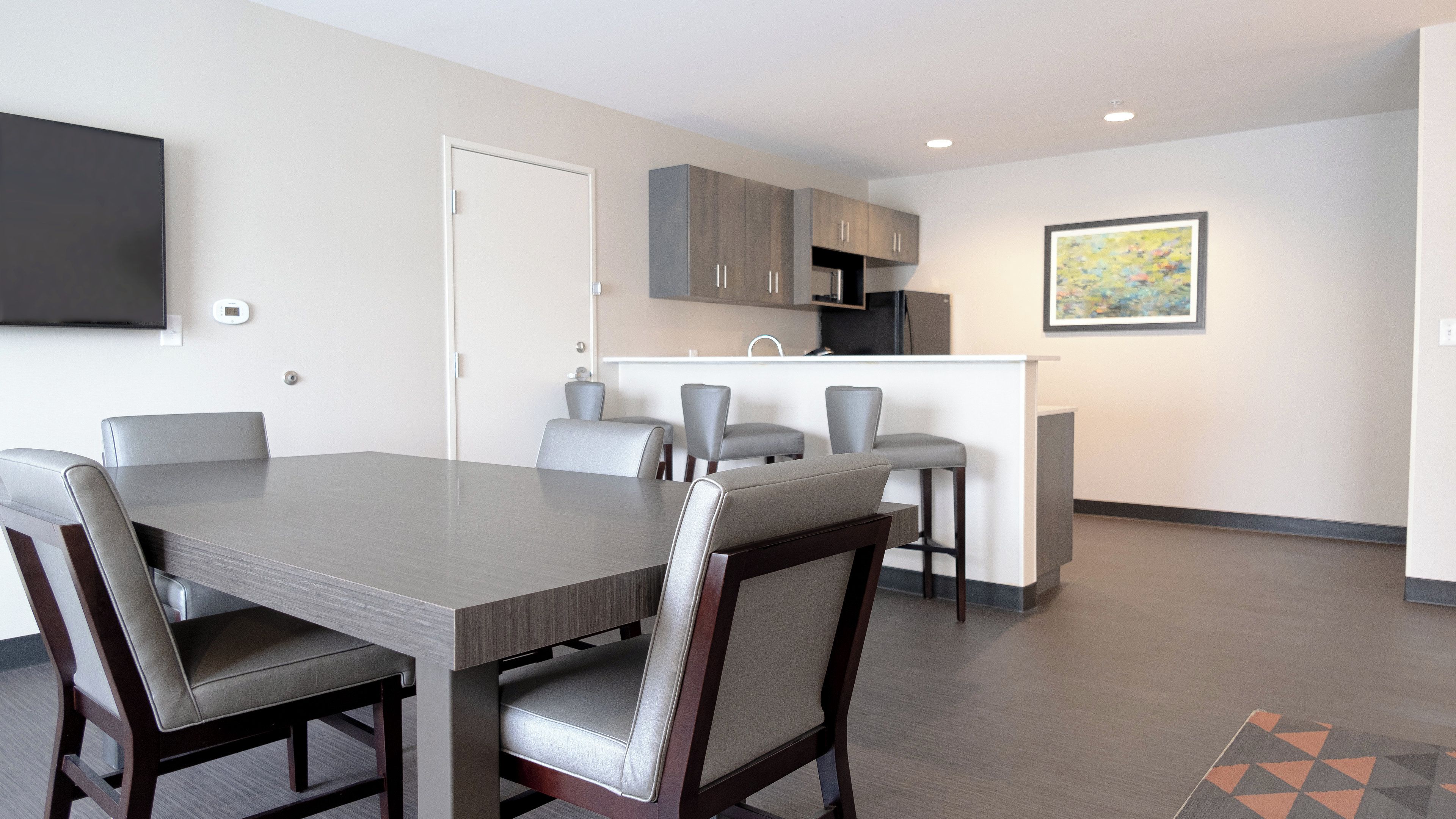 A modern kitchen with grey cabinets, a built-in oven, and a white countertop.