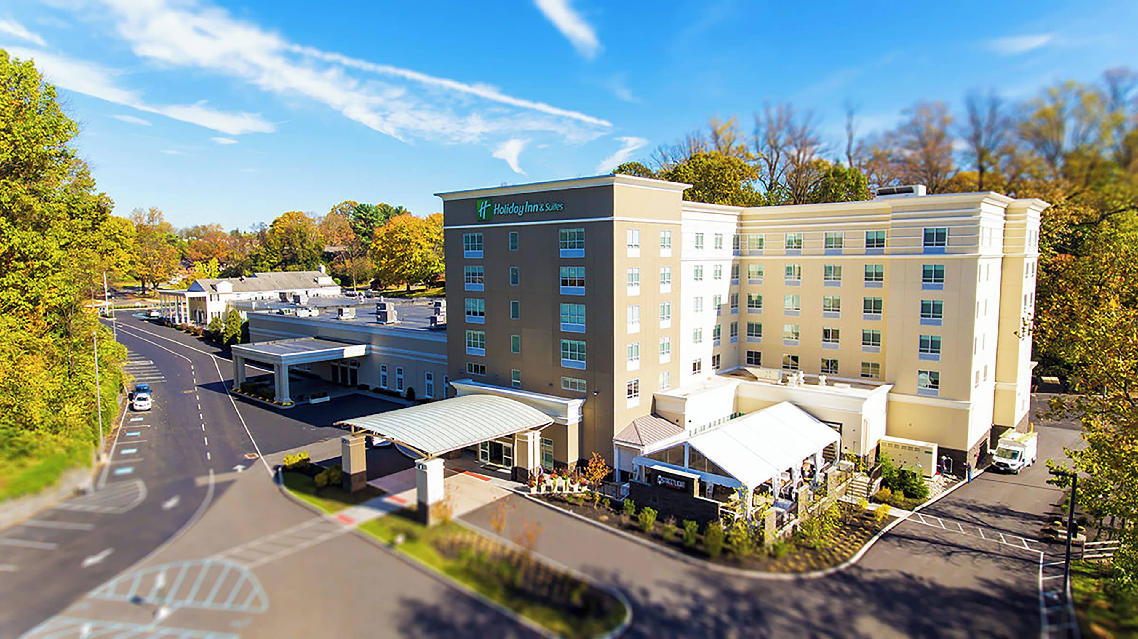 Un Holiday Inn & Suites con estacionamiento, estacionamiento techado y un edificio de varios pisos.