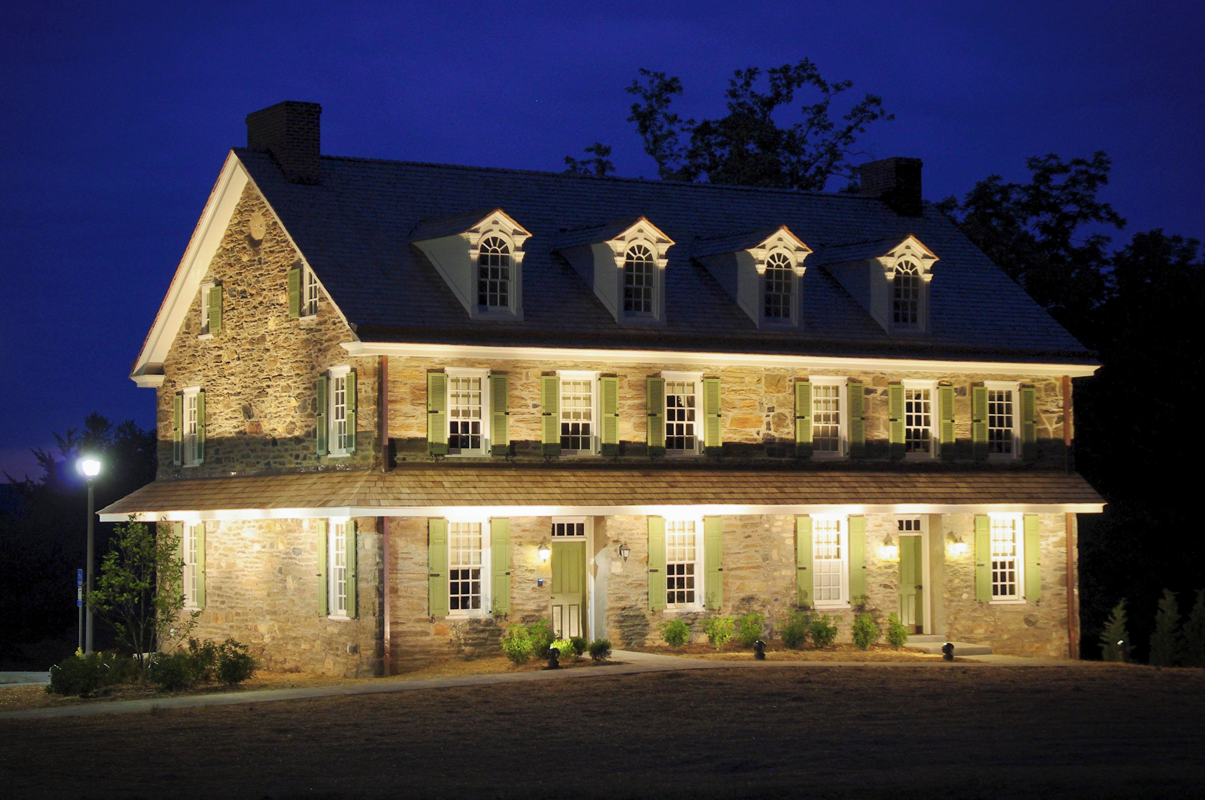 A large stone building with multiple windows and a prominent chimney.