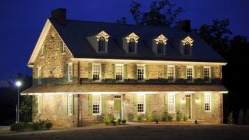 A large stone building with multiple windows and a prominent chimney.