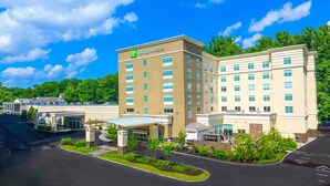A Holiday Inn & Suites hotel with a central courtyard, multiple floors, and a parking lot. - Holiday Inn & Suites Philadelphia W - Drexel Hill by IHG (Drexel Hill)