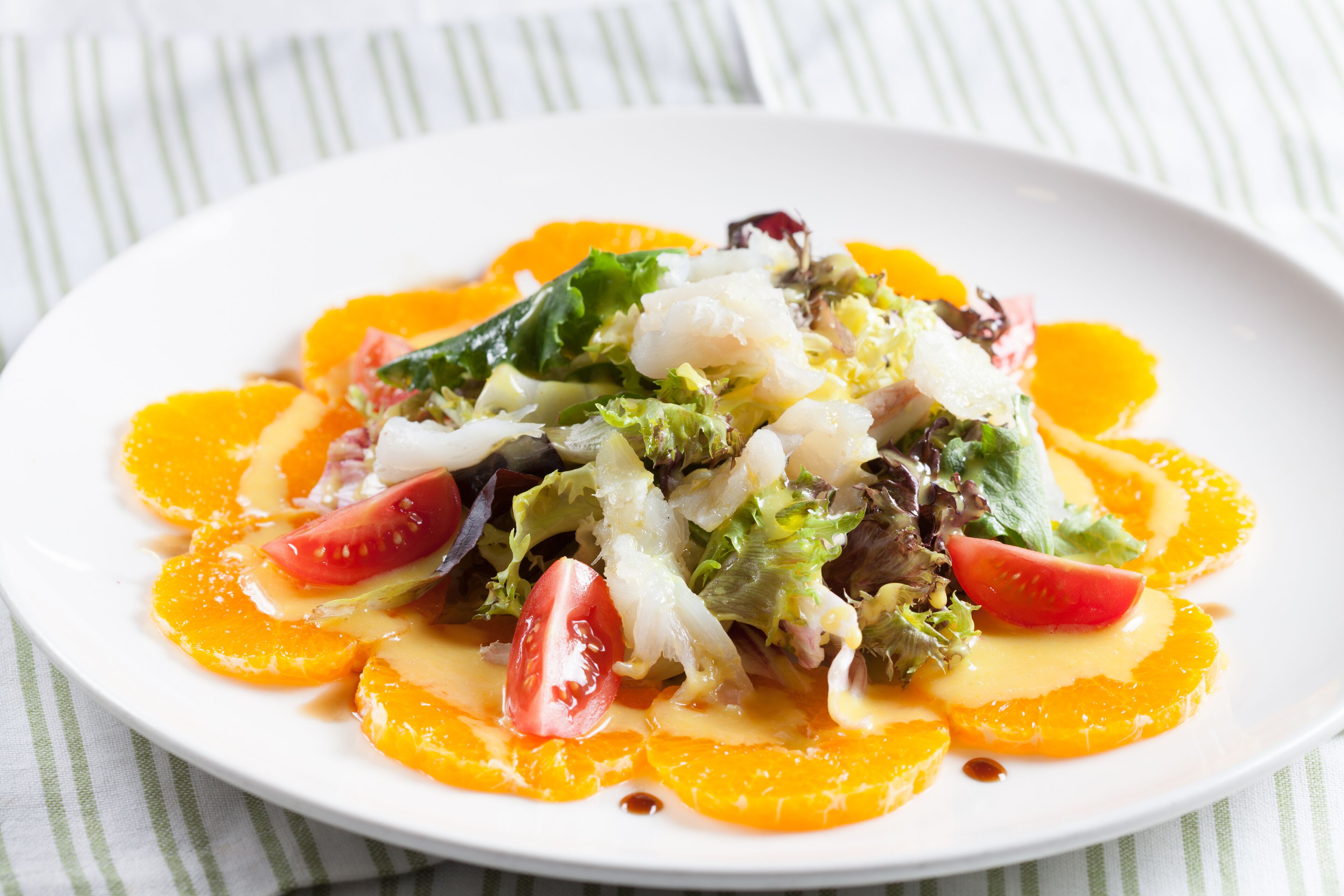 A plate of food with various vegetables and fruit slices.