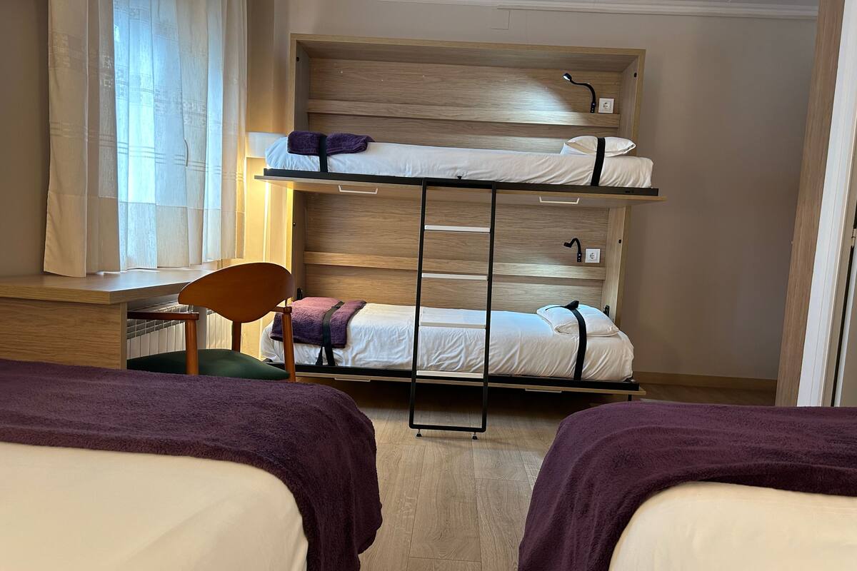 Ein Schlafsaalzimmer mit zwei Betten, einem Schreibtisch und einem Stuhl.