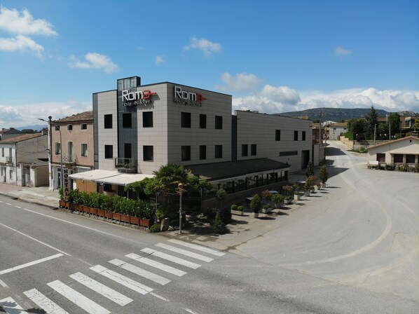 A modern building with a sign reading "Roma" indicating a hostel or restaurant.