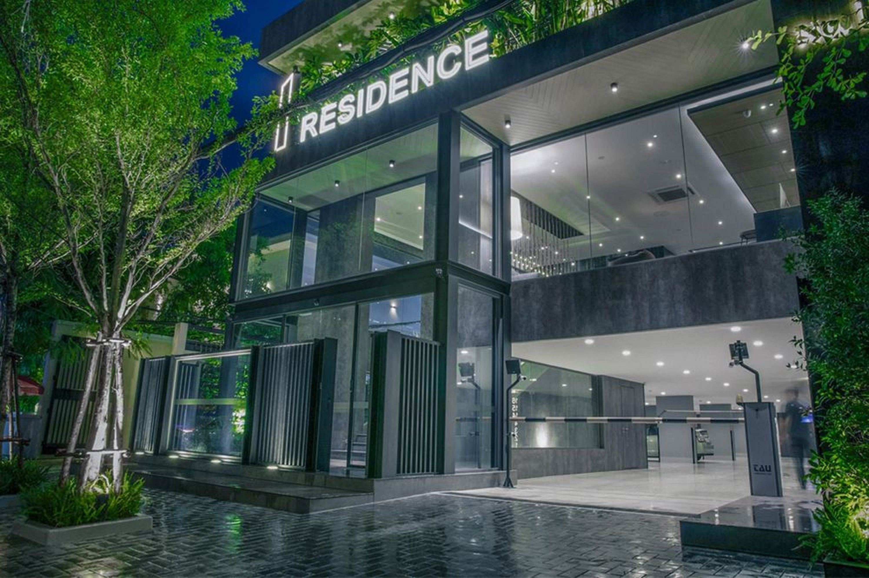 Un edificio moderno con fachada de vidrio y la palabra "RESIDENCE" en el nivel superior.