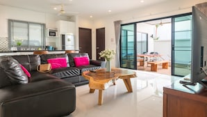 A modern living room with a leather sofa, wooden coffee table, and a flat-screen TV.