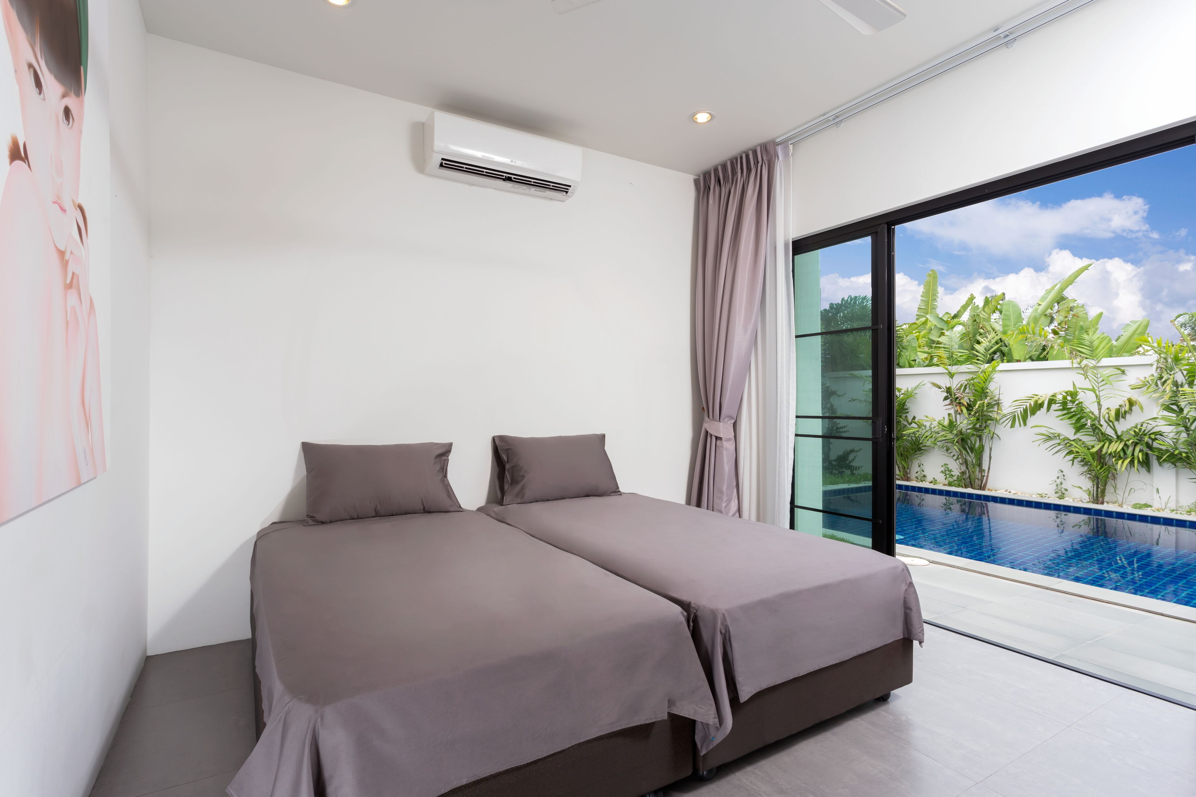 Une chambre moderne dotée d’un grand lit, d’un appareil de climatisation et offrant une vue sur une piscine.