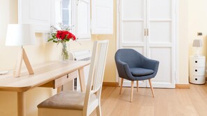 A room with a wooden desk, a chair, a vase with flowers, a white wardrobe, and a lamp. - Mybedcavour (Rome)