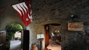 A stone-walled reception area with a sign reading "Reception" and a flag above. - Il Palazzo Boutique B&B (Montalcino)