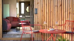 Un intérieur moderne avec un canapé rouge, une table à manger avec deux chaises et une cloison en bois.