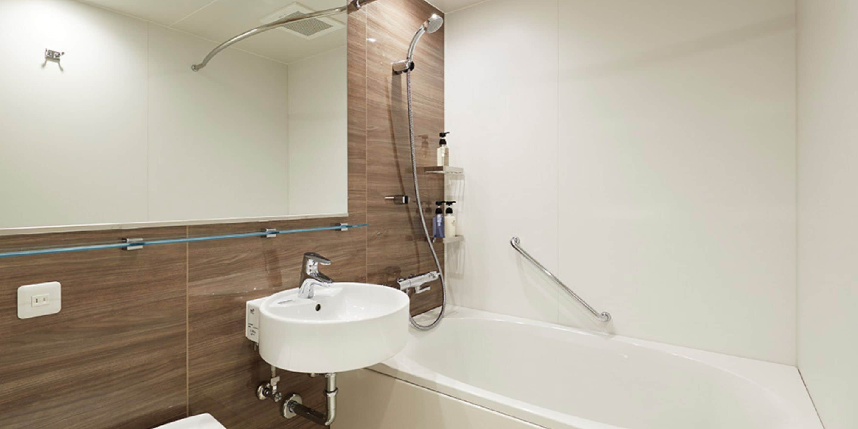 Une salle de bain moderne avec un lavabo blanc, une baignoire et une douche.