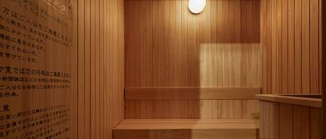 Una sauna de madera con un banco y una pared con texto en japonés.