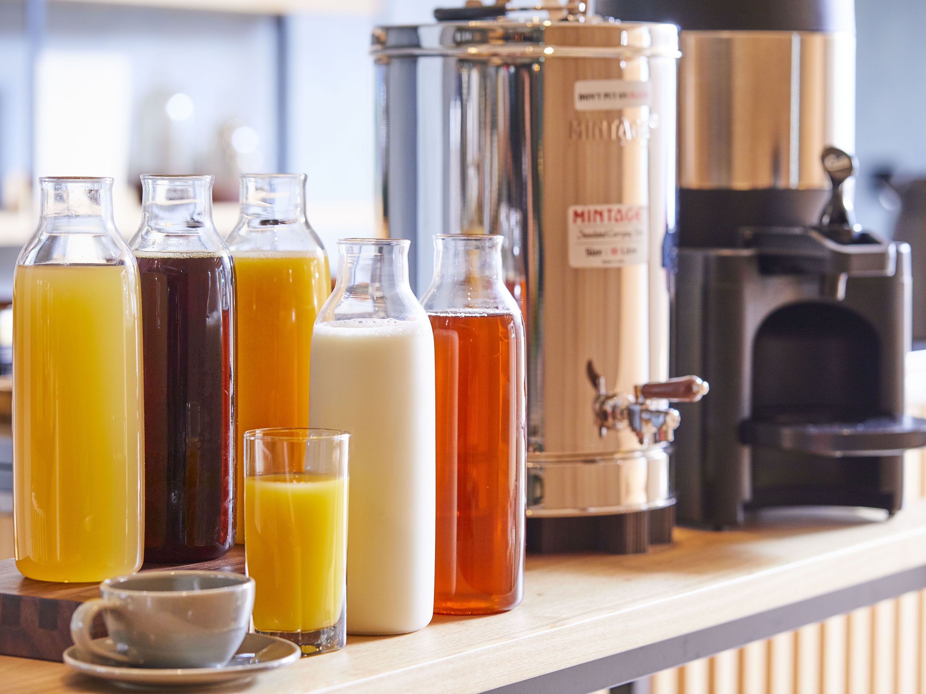 Diversas garrafas de bebida e uma máquina de café em um balcão.