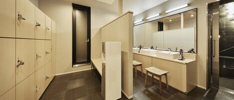 Un baño moderno con taquillas, un lavabo y un espejo.