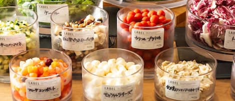 Diversos alimentos en recipientes transparentes con etiquetas, sobre una superficie de madera.