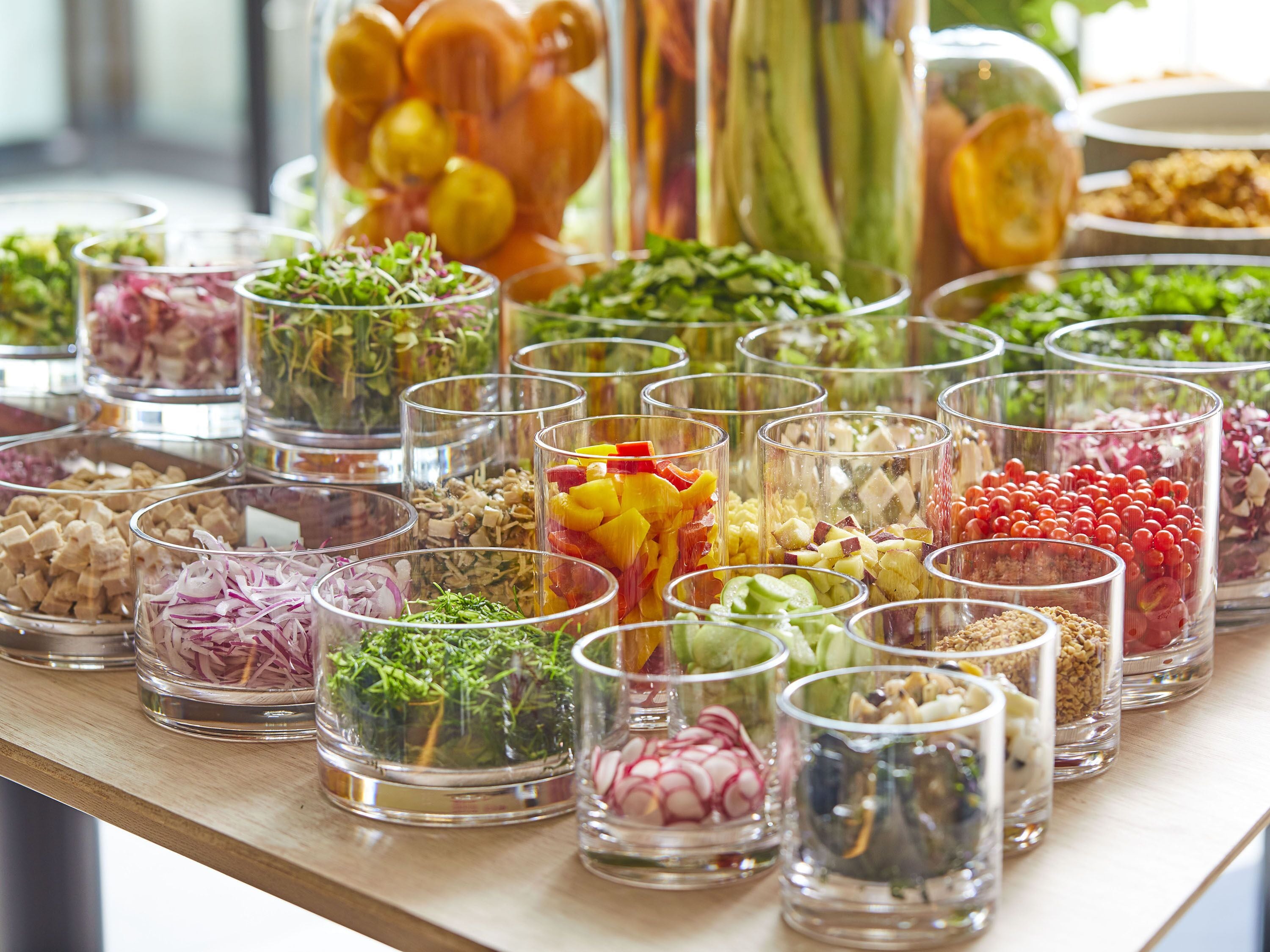 A buffet table with various food items in clear containers.
