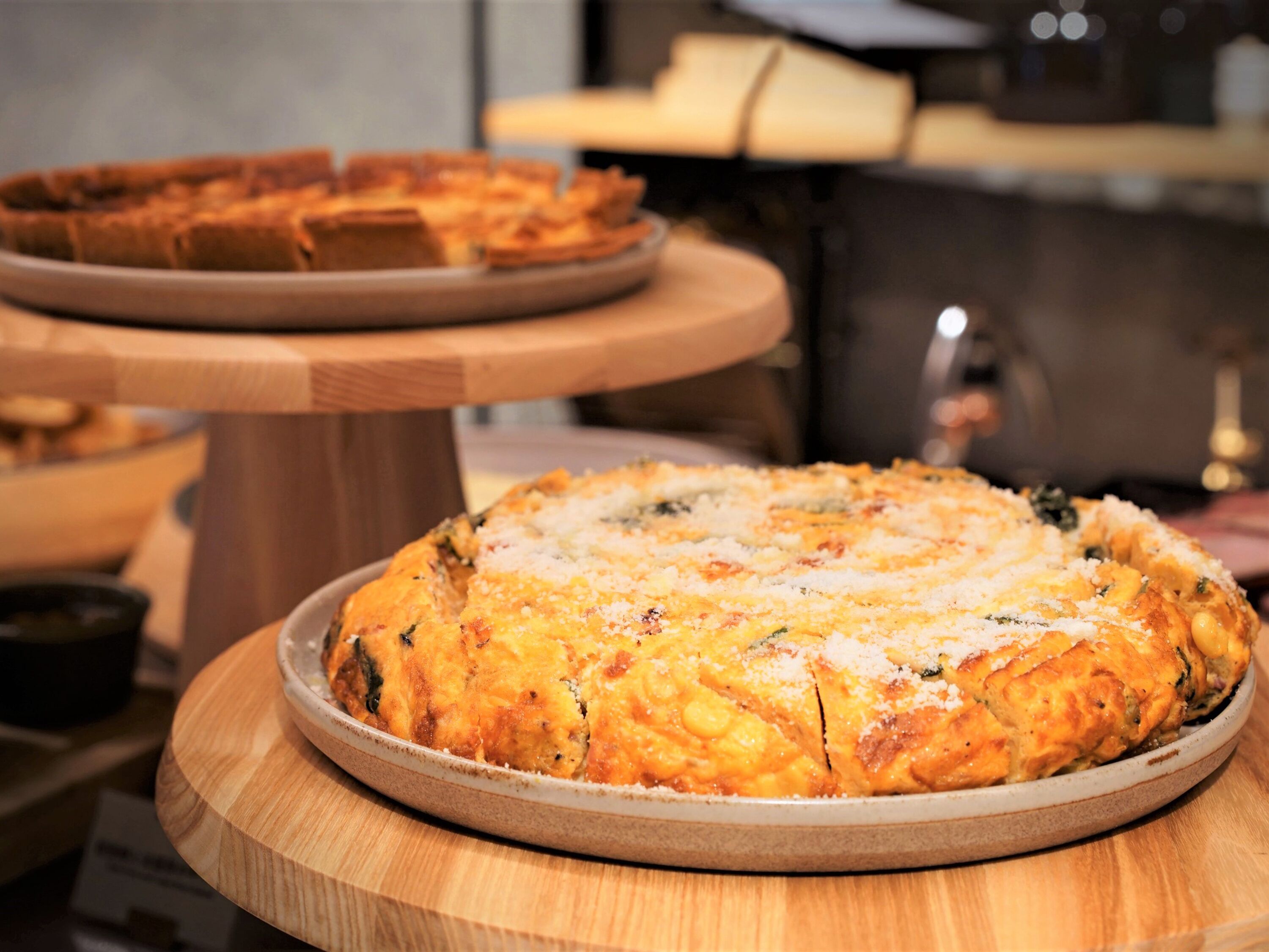 Une pizza sur une planche en bois, avec un arrière-plan flou.