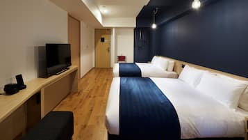 Une chambre d’hôtel équipée d’une télévision, de deux lits, d’un bureau et d’un banc.