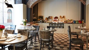 A restaurant with a checkered floor, tables with chairs, and a brick archway. - The Code Hotel (Rome)