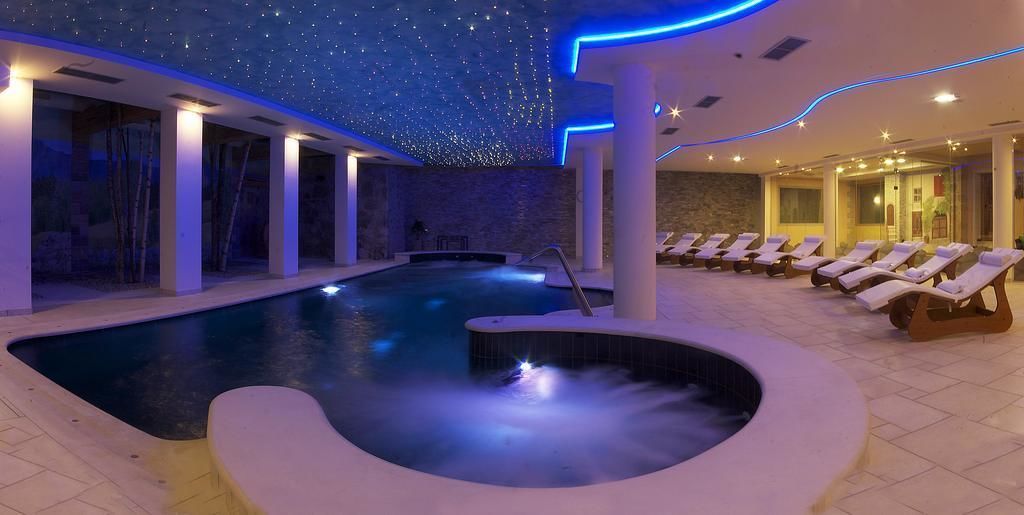 A spa pool with a hot tub, lounge chairs, and a starry ceiling.