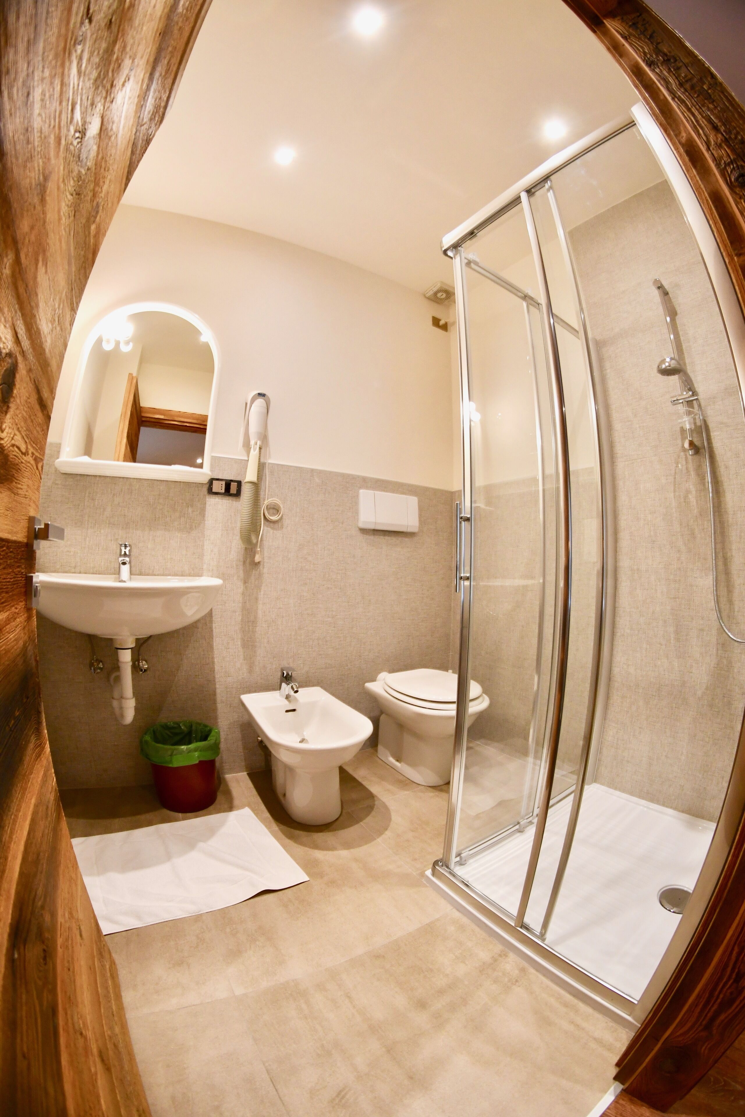 Ein modernes Badezimmer mit einer gläsernen Duschkabine, einem Waschbecken und einer Toilette.