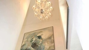 Una escalera con una araña y un cuadro.