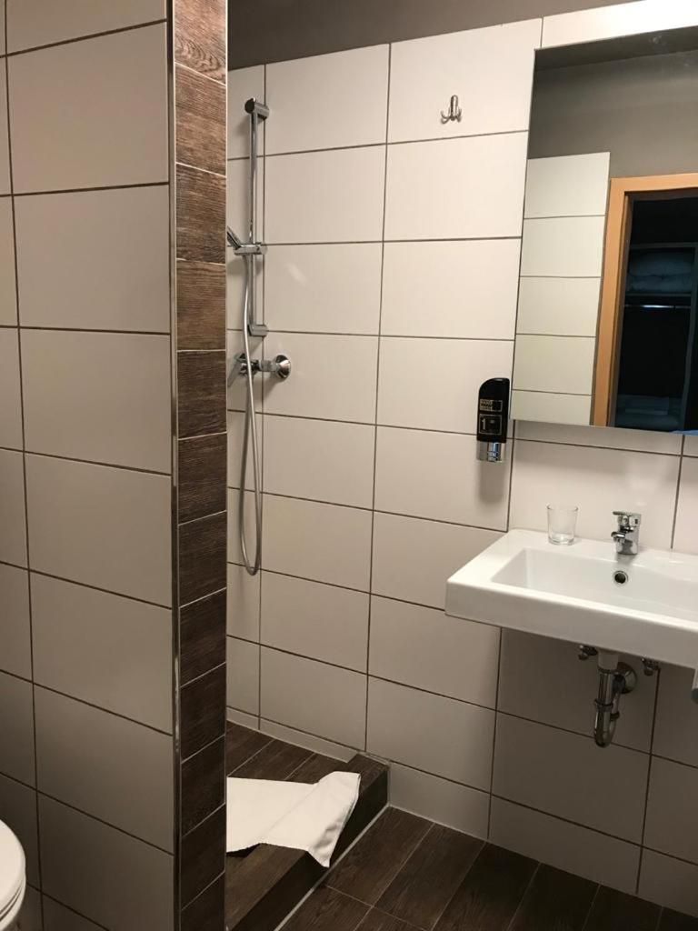A bathroom with a shower, a sink, and a toilet.