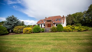 A two-story house with a brick facade, a front porch, and a well-maintained lawn. - Manor House (Lisburn)