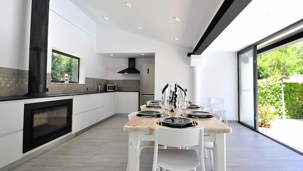 A modern kitchen with a large island, white cabinetry, and a view to the outdoors. - Villa CA NA CARMEN with garden, private pool in Crestatx and very close to POLLENÇA. Quiet zone. - Free Wifi (Sa Pobla)