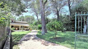 A paved pathway leading to a house with a tiled roof, surrounded by trees and a metal gate. - Villa CA NA CARMEN with garden, private pool in Crestatx and very close to POLLENÇA. Quiet zone. - Free Wifi (Sa Pobla)