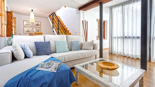 Un salon moderne avec un canapé, une table basse et un escalier.