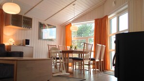 A cozy room with a dining table, chairs, a sofa, and a desk. - Cozy lodge on a hillside with Schleiblick | Sauna | Fireplace | Free Wi-Fi (Kosel)