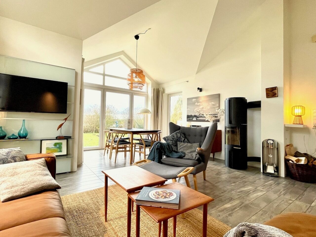 A spacious living room with a large TV, comfortable seating, a dining area, and a fireplace.