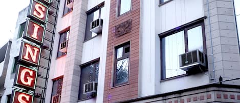 A hotel with a neon sign reading "HOTEL BLESSINGS" and a sign for "KAYE EVENTS".