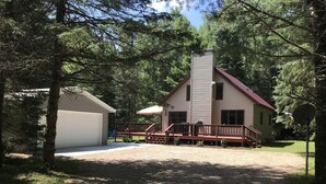 Uma casa de dois andares com varanda coberta e garagem.