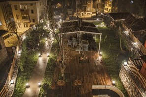A rooftop terrace with a wooden deck, seating areas, and a covered section. - Kaf Konak (Bartin)