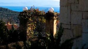 Ein Steinhaus mit Blick auf das Meer und die Berge.